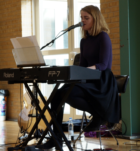Foto viser Caroline Fjerbæk Olsen, der synger og spiller på Forårsudstillingen 2017